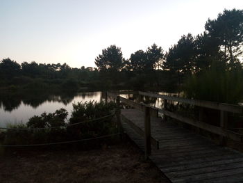 Pier over lake against clear sky