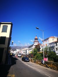 View of city street against blue sky