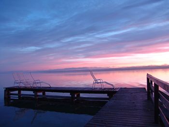 Pier over sea against sky during sunset