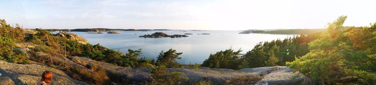 Panoramic shot of rocks by sea against sky