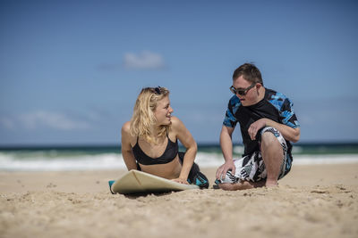 Teenage boy with down syndrome having surf lessons on beach