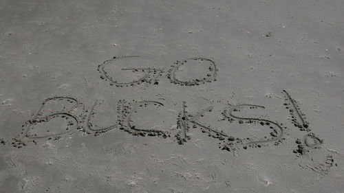 High angle view of text on wet sand