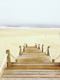 Steps on beach against clear sky