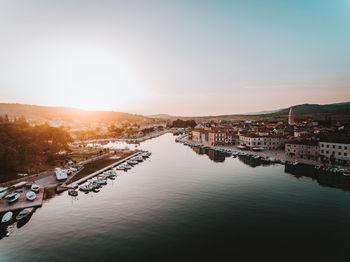 High angle view of boats moored at harbor against sky during sunset