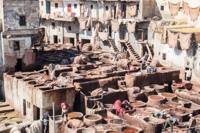 Workers dyeing textiles in clay containers