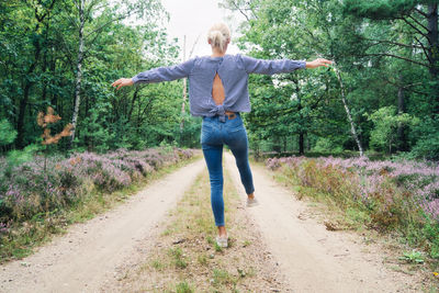 Full length of man with arms raised in forest