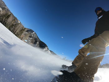 Low angle view of man on snowboarding against sky