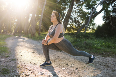 Portrait of young woman exercising on field