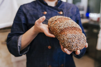 Close-up of man holding loaf of bread