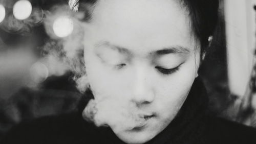 Close-up portrait of young woman smoking