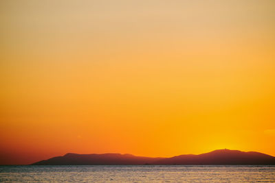 Scenic view of sea against orange sky