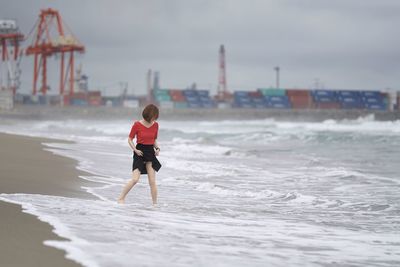 Boy on beach against sky