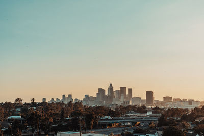 Buildings in city against clear sky