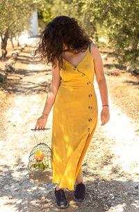 Rear view of woman with yellow umbrella