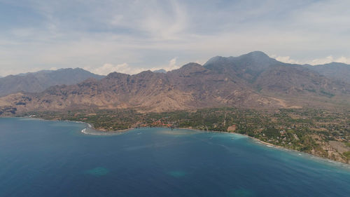 Scenic view of sea and mountains against sky