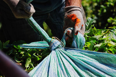 Midsection of worker holding sack during sunny day