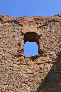 Low angle view of old ruins against clear blue sky