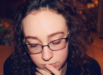 Close-up of young woman in eyeglasses at home