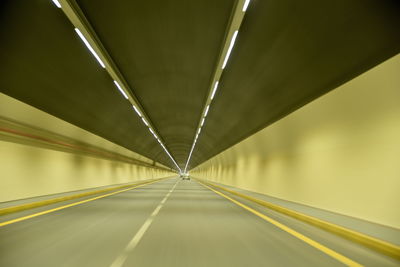 Empty road in illuminated tunnel