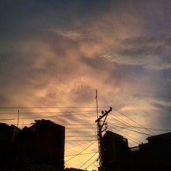 Low angle view of silhouette electricity pylon against sky