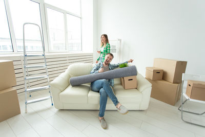 Young woman sitting on sofa at home