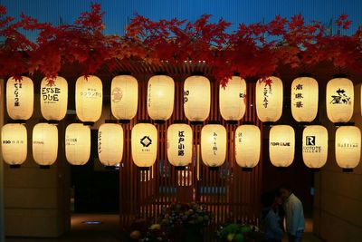 Illuminated lanterns hanging in row