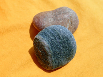 Close-up of pebbles on rock against orange background