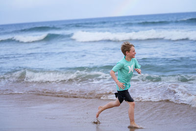 Young boy running on the beach