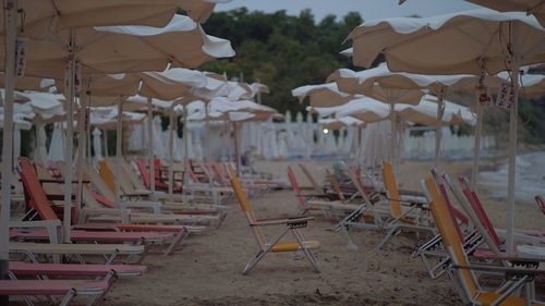 Empty chairs on beach against buildings