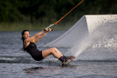 Side view of woman wakeboarding in sea