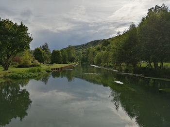 Scenic view of lake by trees against sky