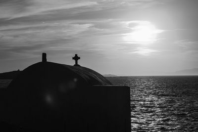 Silhouette man in sea against sky