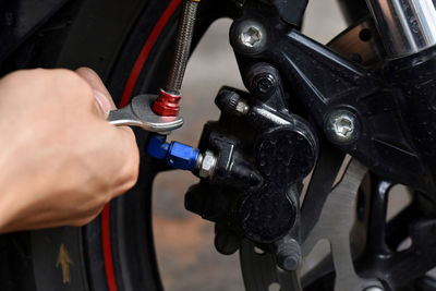 Close-up of man repairing motorcycle