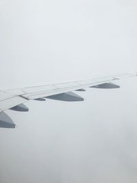 Close-up of airplane wing against clear sky