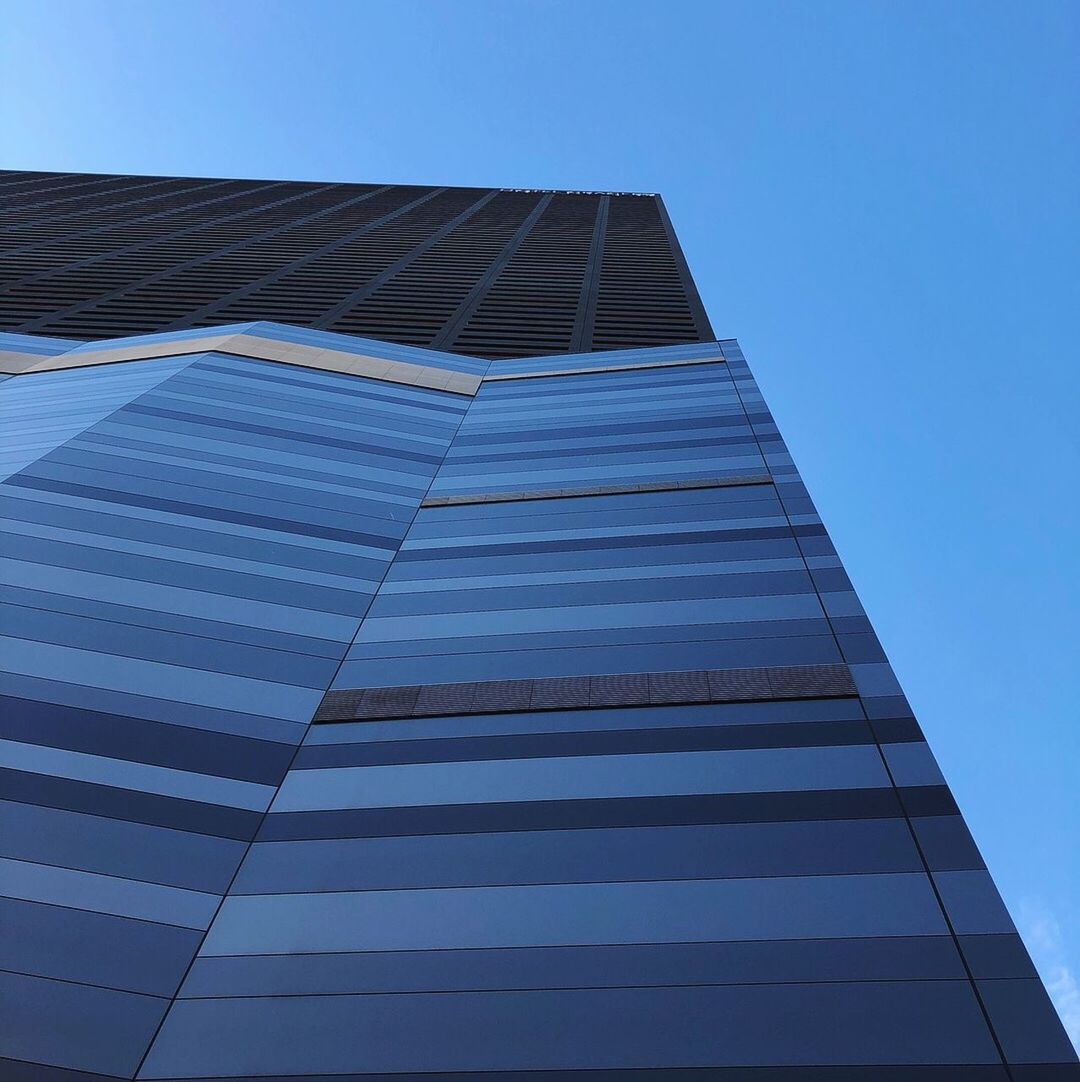 LOW ANGLE VIEW OF SKYSCRAPER AGAINST BLUE SKY