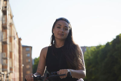 Portrait of young woman with electric push scooter