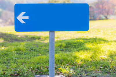 Close-up of road sign on field