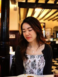 Portrait of beautiful young woman in restaurant