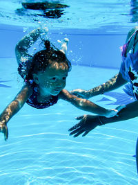 High angle view of baby girl diving  in pool