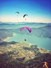 Hot air balloons flying against cloudy sky
