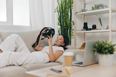 Young woman sitting on bed at home