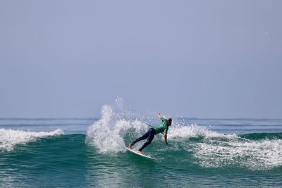 Man surfing in sea against sky