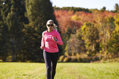 A close up of a woman trail running on an autumn day.