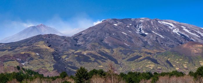 Scenic view of mountain range against blue sky