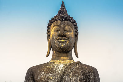 Low angle view of statue against temple against clear sky