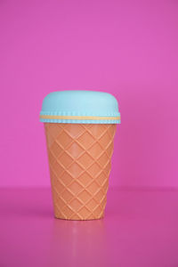 Close-up of coffee cup against pink background