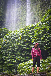 Full length of woman standing by plants