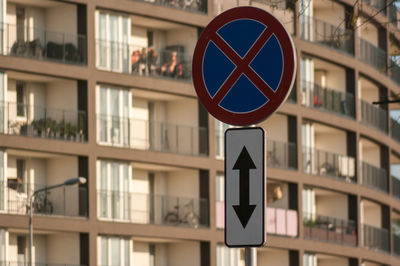 Close-up of road sign against buildings in city