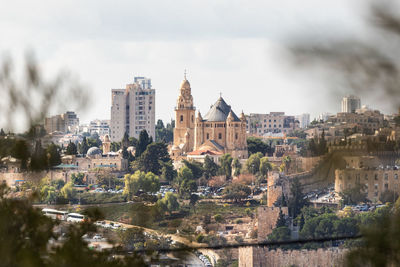 Buildings in city against cloudy sky