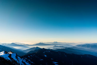 Scenic view of snowcapped mountains against clear blue sky